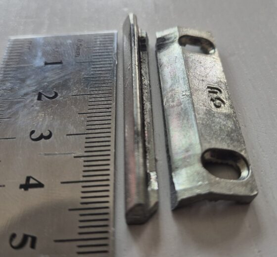 broken door striker plate with ruler